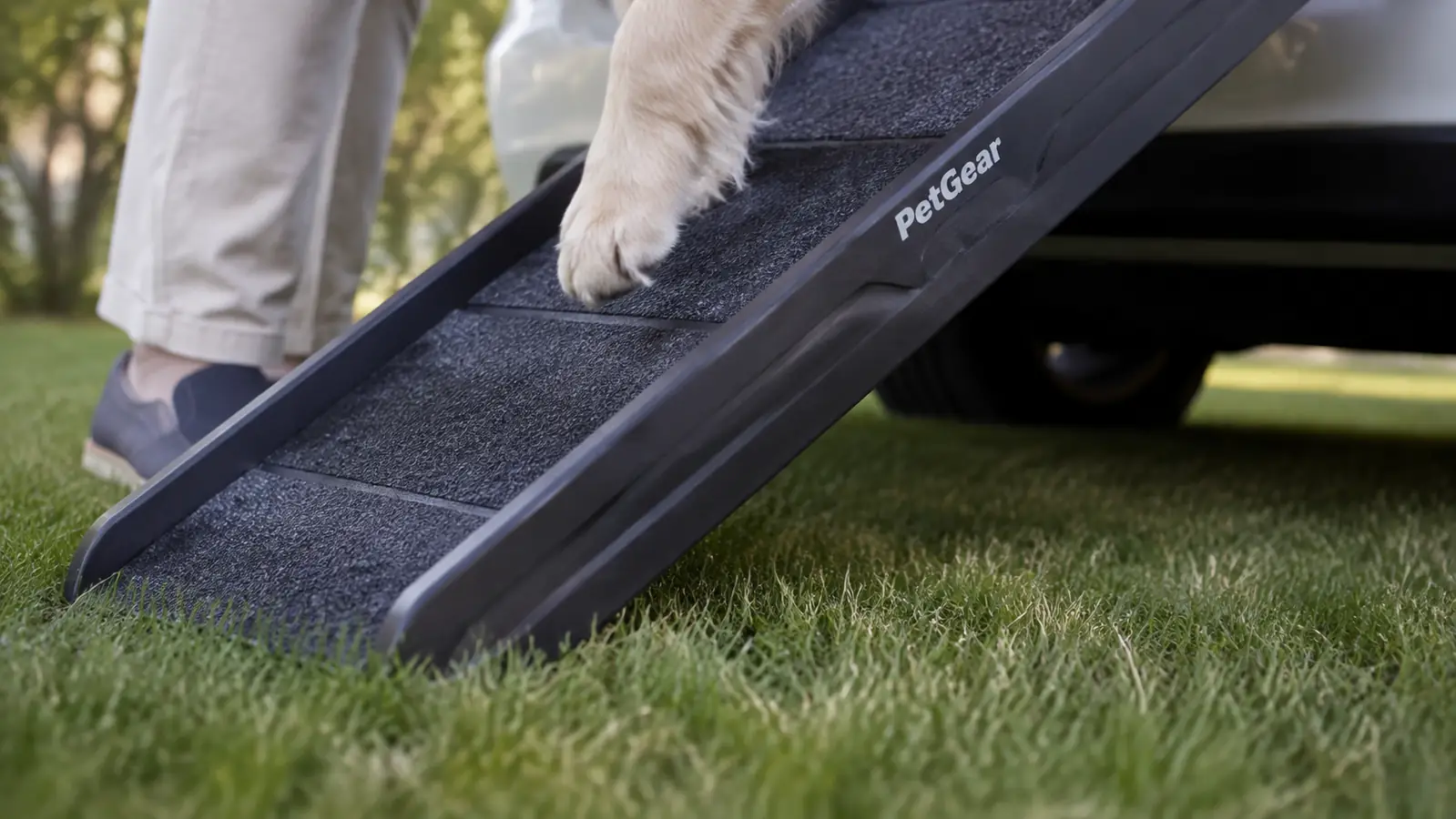 A low close-up of the ramp foot pressed into damp grass, showing the rubber traction surface